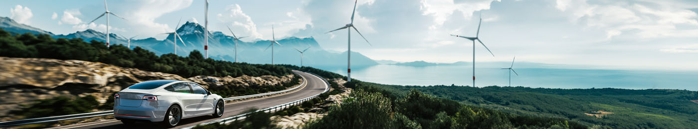 Electric Vehicle (EV) driving on road next to wind turbines